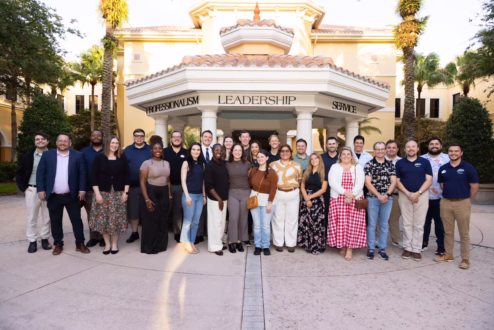 Group of alumni and industry guests posed in front of the Rosen College gazebo