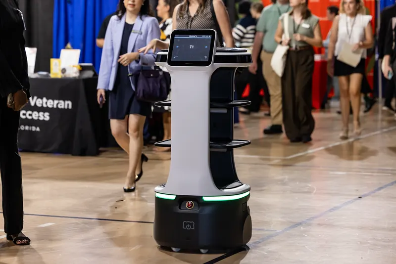 A service robot on the floor at the Rosen College Career Fair